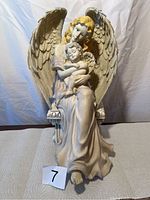 Front view of the hard plastic angel statue with baby angel, showing detailed wings and facial features.