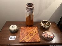 Overview photo showing all five items: jewelry box, ceramic trivet, candy dish, empty gift tin, and tall ceramic glass vase.