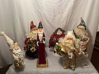Group photo of two tree toppers and four Santa statues varying from 11 to 16 inches tall, showing colors and detail.