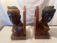 Front view showing both carved male and female bookends side by side, highlighting the detailed carving and size.