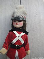 Front view of doll showing uniform details, face, helmet with plume