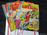 Lot of 6 Archie comic books fanned out showing front covers with varied colorful illustrations. Visible wear on edges and creases on covers.