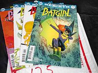 Four Batgirl comic books issues #1, #4, #6, #8 stacked showing front covers.