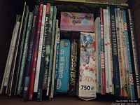 Photo of the spines of assorted kids books including The Cat in the Hat, My First Dictionary, and puzzle books