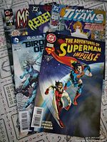 Five comic books laid out showing front covers with visible titles and cover art.