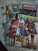 Lot of 8 assorted comic books including Marvel and other series, showing colorful illustrated covers with superheroes such as Cable and Avengers characters.