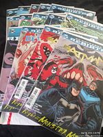 Photo of multiple DC comic books including Batman, Detective Comics, Batgirl Birds of Prey, Green Lantern, Green Arrow, showcasing colorful illustrated covers from DC Rebirth series.