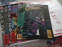 Four Catwoman comic books (#27, #28, #31, #32) shown together with visible wear and some sticker residue