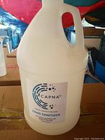 Close-up of a single gallon-sized plastic bottle of Capna hand sanitizer showing label and handle