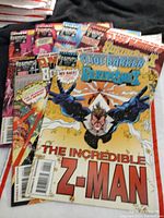 Stack of comic books with visible cover of 'The Incredible Z-Man' and other comics beneath it, showing colorful action scenes and superhero themes.