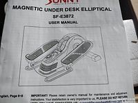 Close-up photo of user manual for Sunny Health & Fitness Magnetic Under Desk Elliptical SF-E3872 showing line drawing and user manual details.