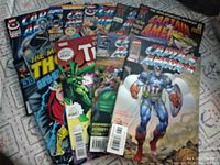 Photo showing multiple Thor and Captain America comic books, edges show wear, displaying collectible comic book covers.