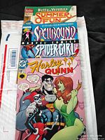 Four comic books stacked showing front covers, visible titles: Betty and Veronica Summer Fun #2, Spellbound #1 Marvel Comics, Spidergirl, Harley Quinn #17