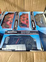 Box containing multiple Regonic multipurpose radios with original packaging visible. The packaging shows the product name and the radios inside.