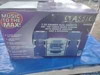 Photo of the boxed stereo system showing brand Classic, model AH8828, listing features like 3 CD drawer, dual cassette, AM/FM tuner, remote control, and 4 speakers.