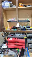 Cabinet interior showing red Craftsman toolbox, ratchets, sockets, wrenches and accessories