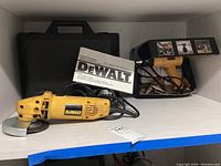 DeWalt angle grinder with carrying case and instruction manual, Seekone heat tool with attachments visible