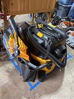 DeWalt wet/dry vacuum cleaner with flexible hose and attached accessories.