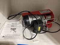 Photo of the hoist and instruction manual showing model number and brand clearly