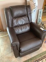 Front view of the dark brown leather La-Z-Boy rocker recliner chair showing padded armrests and cushioned back.