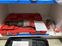 Milwaukee reciprocating saw in red hard plastic case with manual and blades