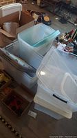 Stack of clear plastic storage tubs and lids with some smaller boxes around, showing quantity and type of tubs.