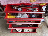 Top view of open five-drawer red Sears Craftsman toolbox showing air tool accessories, fittings, sandpaper rolls and some hand pneumatic tools in drawers.