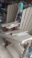 Overall view of two assembled chairs with disassembled table boards and hardware stacked on seat