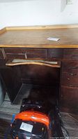 Full view of the vintage jewelers desk wooden top showing minor wear and a paperwork piece on top.