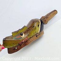 Side view of the traditional African Guro baobab wood mask highlighting the carved form and color details.