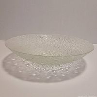 Side view of clear bubble glass bowl showing the textured surface and shallow depth