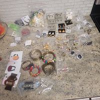 Full assortment of the jewelry lot spread on countertop showing variety of items and packaging