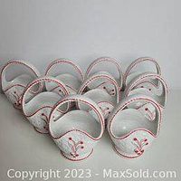 Set of 9 mini ceramic white baskets with red painted floral accents and braided handles, arranged in rows