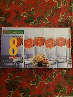 Box packaging showing set of 8 glass tumblers with printed image of each glass with poinsettia designs