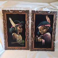 Full view of the two black felt paintings side by side with carved wooden frames