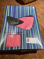 Front of blue and green striped box showing pink electric blanket inside and Beacon brand label.