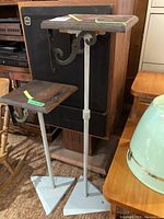 Two adjustable stands with square wooden tops and metal bases, shown side by side in room context