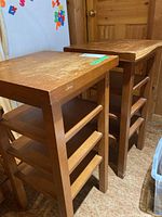 Two wooden tables with three shelves each, showing front and side views.