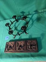 Top view of metal candelabra showing five candle holders and surrounding spikes on a circular frame.