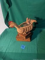 Photo of woven chicken basket showing intricate weaving and red accent details, sitting on a smaller decorative box.