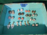 Overview of 13 pairs of clip-on earrings in a teal box, showing various styles and colors including gold, silver, pearl, coral, and multicolor.