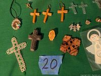 Top view image showing the collection of various crosses, religious pendants, and figurines on green fabric.