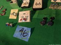 Photo of assorted earrings including crystal, art glass, silver-toned metal pairs, and colorful studs in boxes.