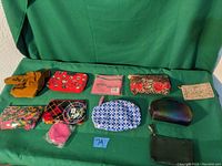 Photo showing all 9 makeup bags arranged on a green backdrop, displaying variety in color and style.