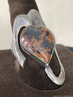 Close-up side angle of bloodstone ring showing teardrop-shaped stone and silver band with patina.