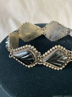 Close-up photo of the polished black onyx stones set in leaf-shaped sterling silver frames with bead detailing on the bracelet.