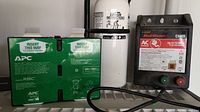 Photo of APC 6V 9Ah battery, Zareba Bulldog C4465 fence controller, and white fire extinguisher arranged on shelf