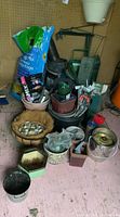 Wide view showing assorted garden pots, bags of potting soil, compost buckets, plant labels, and decorative stones