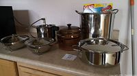Full view of the cookware set including stock pot, double boiler, casserole dishes, saucepan, and freezer bags.
