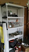 Full view of shelving unit with items stored on shelves.